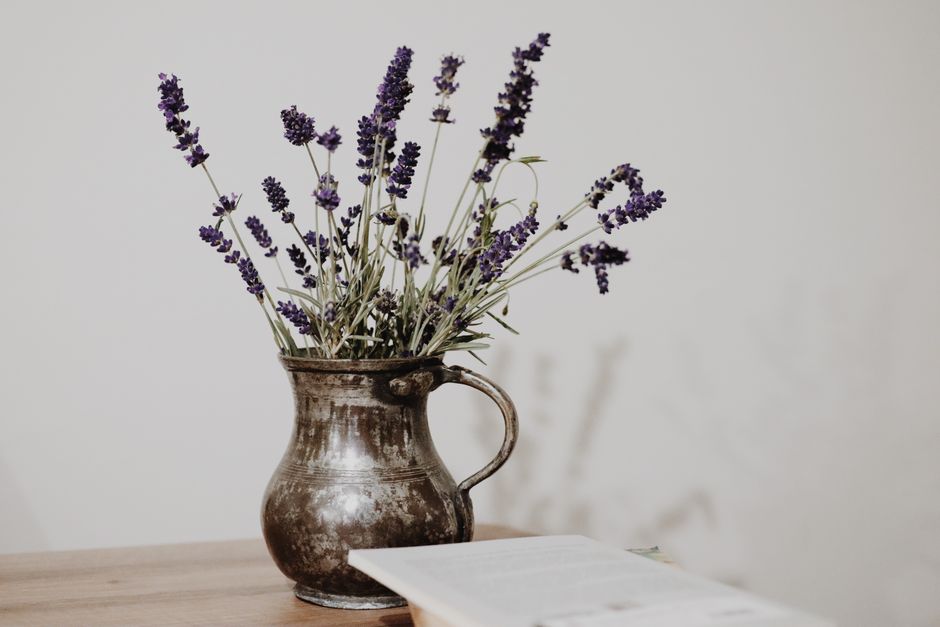 Lavender vase on minimalist wooden table.